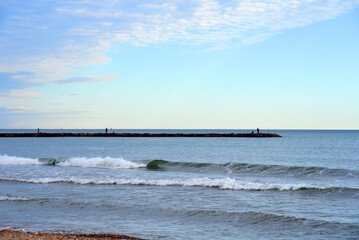 Pier Beach shore. Waves at sea. Waves at sea during storm and wind. Wave from the sea goes on land to the beach. Splashing Waves in ocean, background, texture. Wave at Rising Storm.