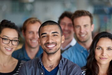 Feeling proud of our achievments. Shot of a smiling group of coworkers standing in an office.