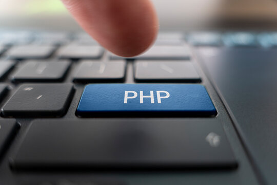 PHP logo on pc keyboard. Writing code PHP programming. Creating web projects in Hypertext Preprocessor language. Website development. finger presses the button.