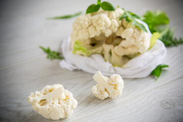 inflorescences of small cauliflower on a light wooden table