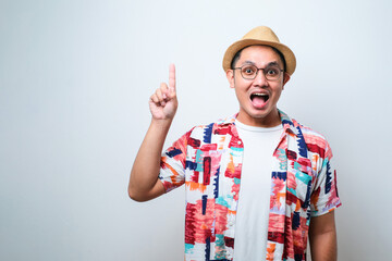 Naklejka premium Asian traveler man intending to realizes the solution while lifting a finger up