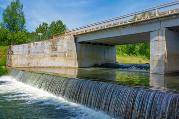 Dam and bridge on the site of a former small hydroelectric power station on the Suenga River