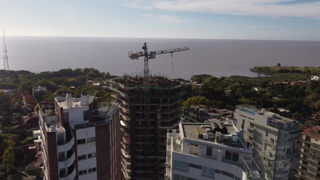 Aerial view of crane on top of building roof  under construction and sea in background, Buenos Aires in Argentina
