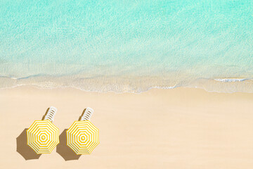 Fototapeta na wymiar Aerial view of sunbed, lounge, yellow umbrella on sandy beach. Summer and travel concept. Blue, turquoise transparent water surface of ocean, sea, lagoon. Aerial, drone view