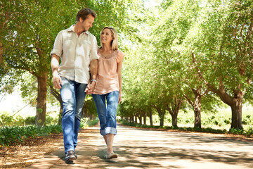Enjoying a summer walkabout. Shot of a mature couple enjoying a walk in the park.