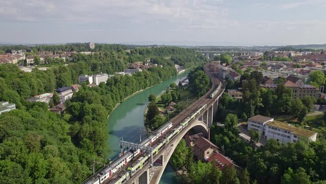 Lorraine railway viaduct over River Aare with crossing BLS and SBB trains at City of Bern, Capital of Switzerland, on a blue cloudy summer day. Movie shot June 16th, 2022, Bern, Switzerland.