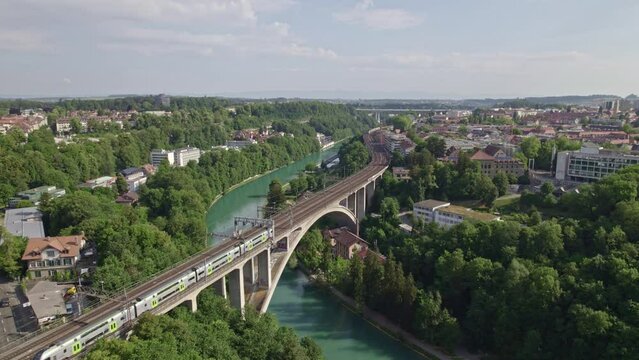 Lorraine railway viaduct over River Aare with crossing BLS trains at City of Bern, Capital of Switzerland, on a blue cloudy summer day. Movie shot June 16th, 2022, Bern, Switzerland.