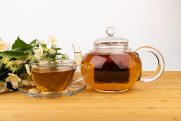 Composition with cup of jasmine tea and flowers on light background