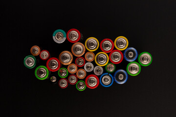 Composition with alkaline batteries on black background. Chemical waste. Top view