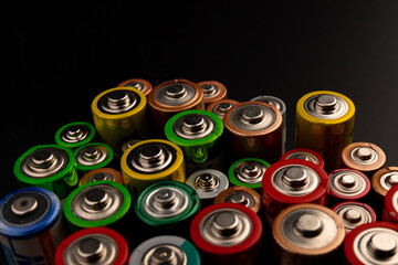 Composition with alkaline batteries on black background. Chemical waste. Top view