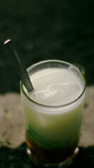 Es cendol, Cendol is a sweet ice dessert drink from Indonesia, which contains green rice flour, coconut milk, and palm sugar syrup. With blurred background.