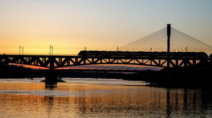 Fototapeta na wymiar Traffic on the railway bridge. Train at sunset.