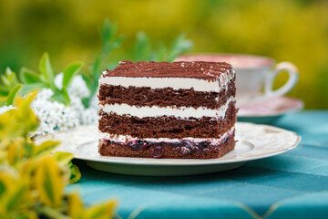 A piece of cake and a cup with a drink on the table.