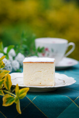 A piece of cake and a cup with a drink on the table.