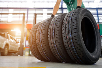 An auto repair shop installs four new tires. The blurred background features a car in the industry's stock blur, four new tires being changed in an auto repair shop, and four wheels