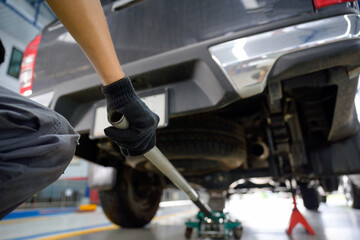 Male car mechanic using a car lift tool To make a tire change. Auto repair service concept.