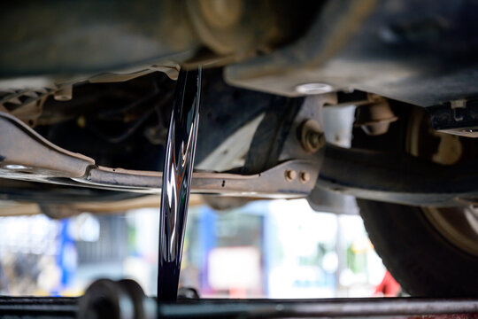 Close-up shot of old car engine oil draining from engine to change new oil at the service center or oil change shop