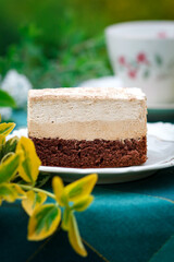 A piece of cake and a cup with a drink on the table.