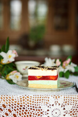 A piece of cake and a cup with a drink on the table.