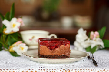 A piece of cake and a cup with a drink on the table.
