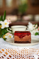 A piece of cake and a cup with a drink on the table.
