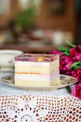 A piece of cake and a cup with a drink on the table.