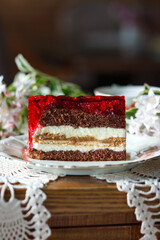 A piece of cake and a cup with a drink on the table.