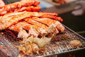 Grilled king crab legs displayed in a traditional market