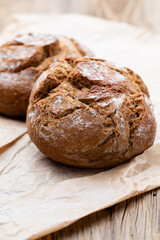 Gold rustic crusty loaves of bread and buns on wooden background. Still life captured from above top view, flat lay.