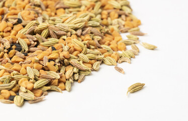 Panch phoron  or panchpuran  tradicional Indian five spice seeds  blend for cooking  consisting of fenugreek, fennel, cumin, mustard seeds, onion seeds or black cumin on white as food background