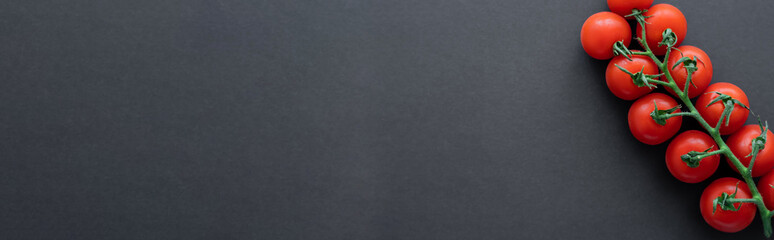 Top view of cherry tomatoes on black background, banner.