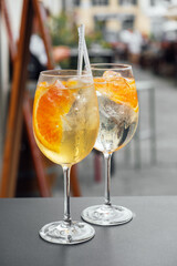 Two glasses of Spritz cocktail served on the terrace of urban bar. Popular Italian wine based beverage and summer aperitif refreshing drink.