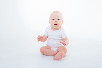 baby boy in white bodysuit sitting on a white background