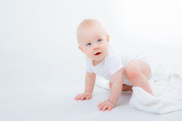 baby boy in a white bodysuit sits with a teddy bear on a white background