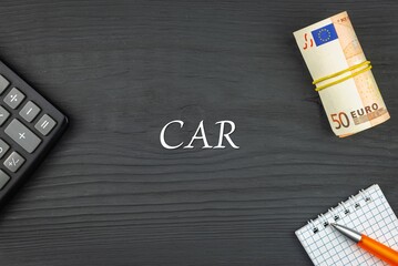 CAR - word (text) and euro money on a wooden background, calculator, pen and notepad. Business concept (copy space).