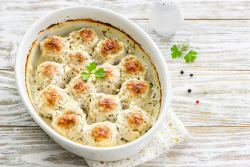 Sour cream turkey  meatballs in baking dish on wooden background. Top view, copy space, flat lay.