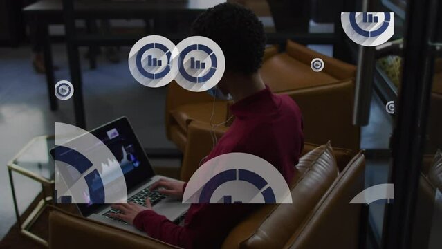 Animation of diagram icons over african american businesswoman using laptop with face mask