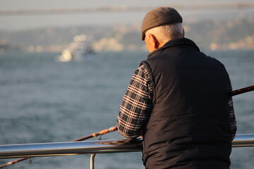 Obraz premium old man fishing in istanbul bosphorus