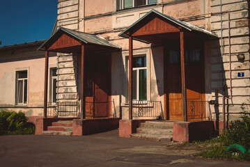 An old wooden building with two porches on a sunny day