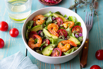 Salad with shrimps, avocado, tomatoes, onions and seeds. Healthy eating. Diet.