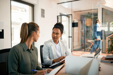 Fototapeta premium Two businesswomen cooperating while analyzing reports in office.