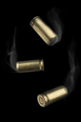 Cartridge cases with smoke falling on black background