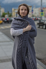 Street portrait of a young woman dressed in a gray cardigan.