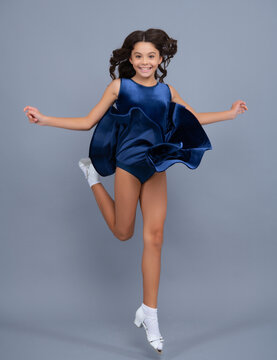 Happy girl face, positive and smiling emotions. Full length teenager with movement dress. Young teen child with flowing skirt. Teen girl fluttering dress in motion, isolated on gray.