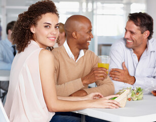 Networking over a sandwich.... A pretty young woman enjoying lunch with her colleagues.