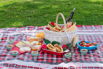 tablecloth with basket and picnic food on the lawn outdoors