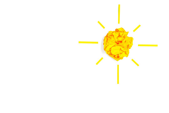 Sun shape made from yellow paper on white