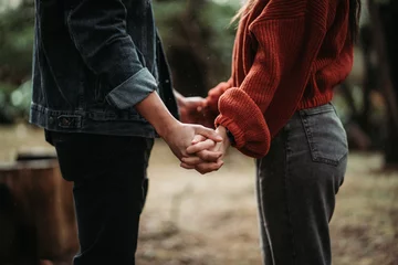 Fotobehang Couple holding hands in the woods © Roberto Saavedra