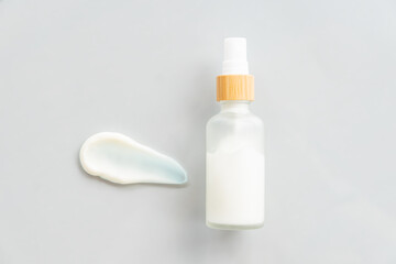 Skincare cosmetic cream or lotion swatch smear smudge on gray color background. White creamy hygiene beauty product in a jar. flat lay, copy space