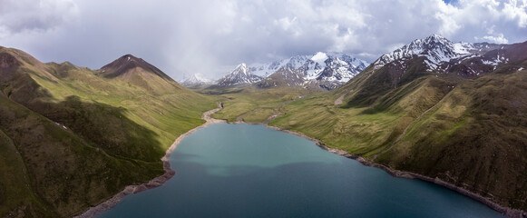 High aerial panorama of the Tian Shan Mountains and a beautiful high altitude lake in Kyrgyzstan.